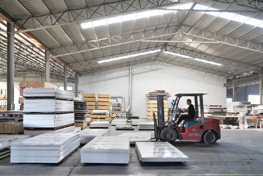 Forklift loading PVC marble sheets for bulk shipment in factory warehouse