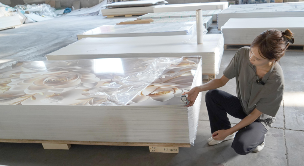 Worker measuring thickness of PVC marble sheet during factory quality inspection